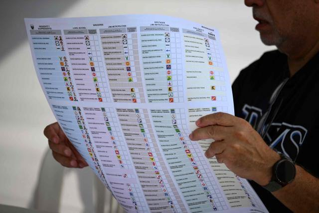 A polling station official counts ballots during the setting up of a polling station in Lima on April 12, 2026, during the presidential election. Peruvians will elect a new president from a record field of 35 candidates to lead a country plagued by organized crime and chronic political instability. (Photo by Luis ROBAYO / AFP)