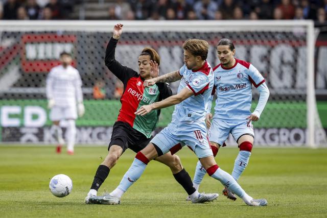 NEC Nijmegen's Japanese midfielder #23 Kodai Sano (L) fights for the ball with Feyenoord's Dutch midfielder #40 Luciano Valente (C) and Feyenoord's French forward #23 Anis Hadj Moussa (R) during the Dutch Eredivisie football match between NEC Nijmegen and Feyenoord Rotterdam at the De Goffert stadium in Nijmegen on April 12, 2026. (Photo by Bas Czerwinski / ANP / AFP) / Netherlands OUT