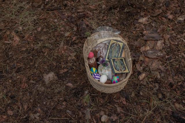 A basket with traditional cakes and other food is placed on the ground during a prayer service of Ukrainian military members of the 33rd separate mechanised brigade to celebrate Orthodox Easter, in the Kharkiv region, on April 12, 2026, amid the Russian invasion of Ukraine. (Photo by Roman PILIPEY / AFP)