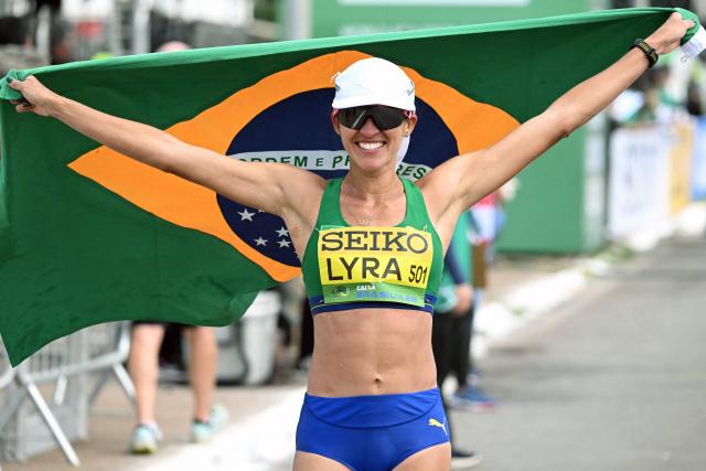 Brazil's Viviane Lyra celebrates with the national flag after getting the fifth place at the World Athletics Race Walking Team Championships women's marathon, in Brasilia, on April 12, 2026. (Photo by Evaristo SA / AFP)