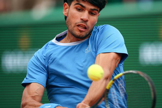 Spain's Carlos Alcaraz plays a backhand return to Italy's Jannik Sinner during the Monte Carlo ATP Masters Series Tournament final tennis match on Court Rainier III at the Monte-Carlo Country Club in Roquebrune-Cap-Martin, south-eastern France on April 12, 2026. (Photo by Valery HACHE / AFP)