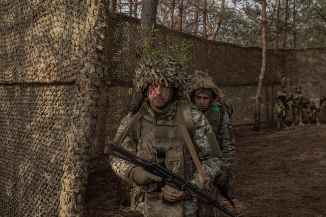 Ukrainian military members of the 33rd separate mechanised brigade walk after a prayer service to celebrate Orthodox Easter, in the Kharkiv region, on April 12, 2026, amid the Russian invasion of Ukraine. (Photo by Roman PILIPEY / AFP)