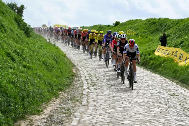The pack of riders cycles on a cobblestone sector during the 6th edition of the Women Paris-Roubaix one-day classic cycling race, 143.1 km between Denain and Roubaix, northern France, on April 12, 2026. (Photo by NICOLAS TUCAT / AFP)
