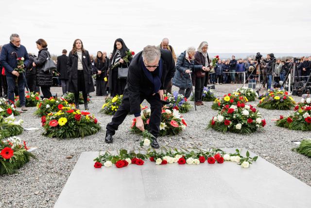 German comedian and actor Hape Kerkeling, grandson of former Buchenwald camp prisoner Hermann Anton Kerkeling, lays flowers as he attends the commemoration ceremony at the camp's memorial site in Buchenwald at the memorial site of the former Nazi concentration camp Buchenwald on April 12, 2026, to attend the commemoration ceremony to mark the 81th anniversary of the liberation of the Buchenwald Nazi concentration camp at the camp's memorial site near Weimar, eastern Germany. From 1937 to 1945, almost 280,000 victims of the Nazis were imprisoned in Buchenwald concentration camp and its satellite camps; more than 56,000 were murdered or died as a result of inhumane conditions. Among the prisoners were Jews, Roma, domestic political opponents of the Nazis, and forced laborers from Eastern Europe. Buchenwald is one of the most symbolically significant and best-known former concentration camps in Germany. (Photo by Jens SCHLÜTER / AFP)