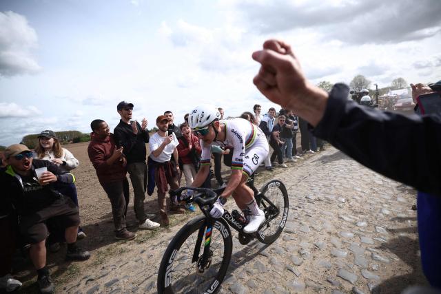 Spectators watch UAE Team Emirates XRG's Slovenian rider Tadej Pogacar riding a cobblestone sector during the 123rd edition of the Paris-Roubaix one-day classic cycling race, 258.3 km between Compiègne and Roubaix, northern France, on April 12, 2026. (Photo by Anne-Christine POUJOULAT / AFP)