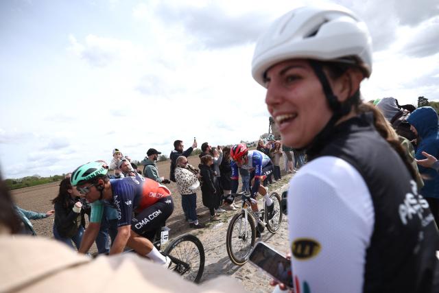 Spectators wath the pack riding a cobblestone sector during the 123rd edition of the Paris-Roubaix one-day classic cycling race, 258.3 km between Compiègne and Roubaix, northern France, on April 12, 2026. (Photo by Anne-Christine POUJOULAT / AFP)