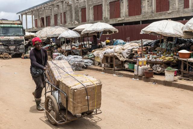 A man pushes a cart full of boxes at a market in Bamenda, on April 12, 2026. (Photo by PATRICK MEINHARDT / AFP)