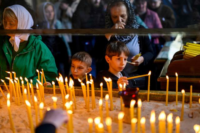 Children light church candles during the Orthodox Easter service at the Patriarchal Church of St. George, in Istanbul on April 12, 2026. (Photo by Yasin AKGUL / AFP)