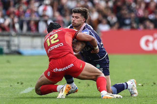 Bordeaux-Begles' French fly-half Matthieu Jalibert (R) is tackled by Toulouse's Argentinian centre Santiago Chocobares  during the European Champions Cup rugby union quarter-final match between Union Bordeaux Belges (UBB) and Stade Toulousain (Toulouse) at the Chaban-Delmas Stadium in Bordeaux, southwestern France, on April 12, 2026. (Photo by ROMAIN PERROCHEAU / AFP)