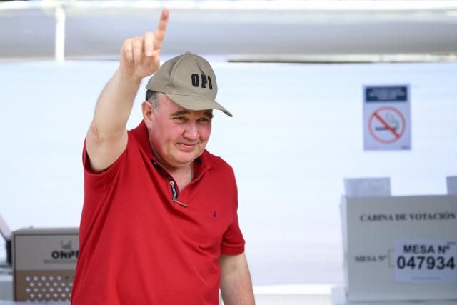 Peru's presidential candidate Rafael Lopez Aliaga, for the Renovacion Popular party, gestures as he votes during the presidential election in Lima on April 12, 2026. Peruvians elect a new president from a record field of 35 candidates to lead a country plagued by organized crime and chronic political instability. (Photo by Luis ROBAYO / AFP)