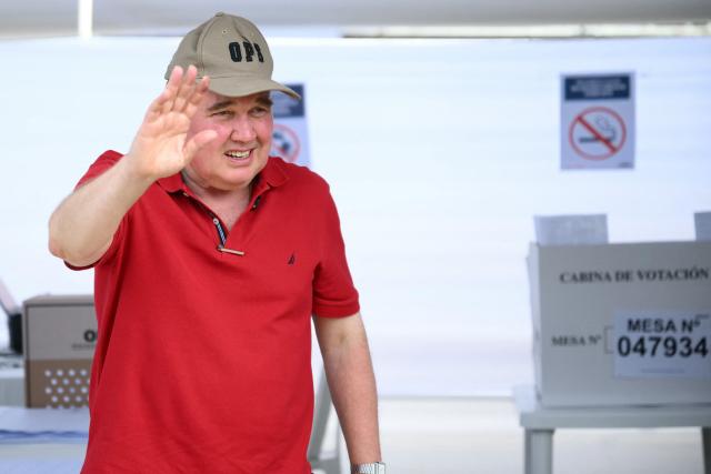 Peru's presidential candidate Rafael Lopez Aliaga, for the Renovacion Popular party, waves as he votes during the presidential election in Lima on April 12, 2026. Peruvians elect a new president from a record field of 35 candidates to lead a country plagued by organized crime and chronic political instability. (Photo by Luis ROBAYO / AFP)