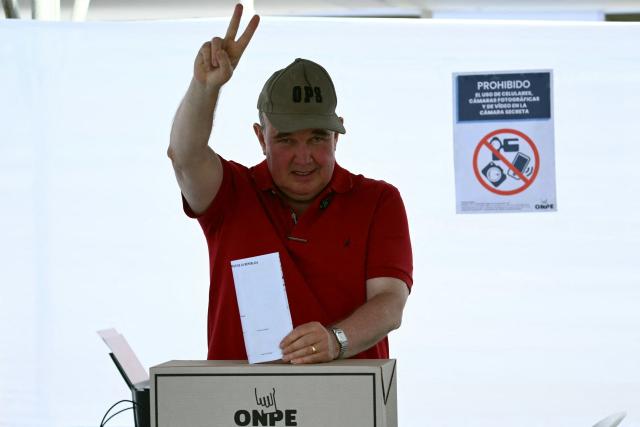 Peru's presidential candidate Rafael Lopez Aliaga, for the Renovacion Popular party, makes a V sign as he casts his ballot during the presidential election in Lima on April 12, 2026. Peruvians elect a new president from a record field of 35 candidates to lead a country plagued by organized crime and chronic political instability. (Photo by Luis ROBAYO / AFP)