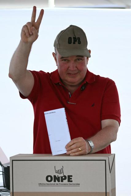 Peru's presidential candidate Rafael Lopez Aliaga, for the Renovacion Popular party, makes a V sign as he casts his ballot during the presidential election in Lima on April 12, 2026. Peruvians elect a new president from a record field of 35 candidates to lead a country plagued by organized crime and chronic political instability. (Photo by Luis ROBAYO / AFP)