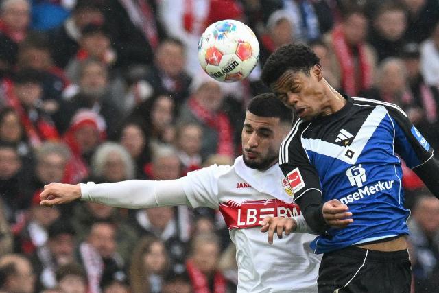 Stuttgart's German forward #26 Deniz Undav (L) and Hamburg's Comorian defender #17 Warmed Omari both jump to head the ball during the German first division Bundesliga football match between VfB Stuttgart and Hamburger SV in Stuttgart, southwestern Germany on April 12, 2026. (Photo by THOMAS KIENZLE / AFP) / ALTERNATIVE CROP