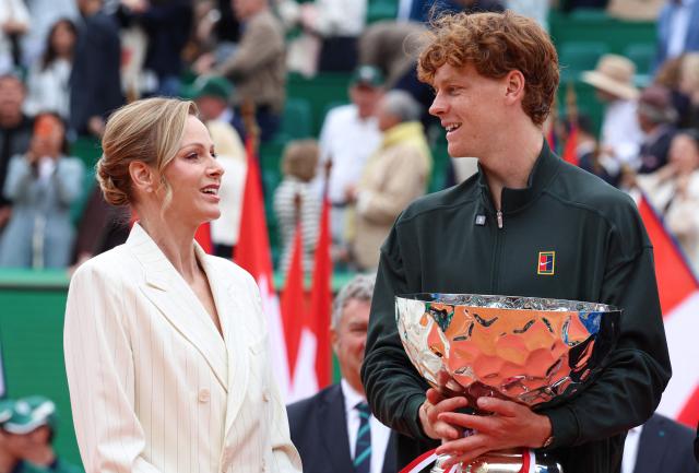 Italy's Jannik Sinner (R) celebrates on the podium flanked by Princess Charlene of Monaco following the Monte Carlo ATP Masters Series Tournament final tennis match against Spain's Carlos Alcaraz on Court Rainier III at the Monte-Carlo Country Club in Roquebrune-Cap-Martin, south-eastern France on April 12, 2026. (Photo by Valery HACHE / AFP) / / NO TABLOIDS WEB & PRINT, NO DAILY MAIL, NO DAILY MAIL GROUP, NO VOICI, NO CLOSER
