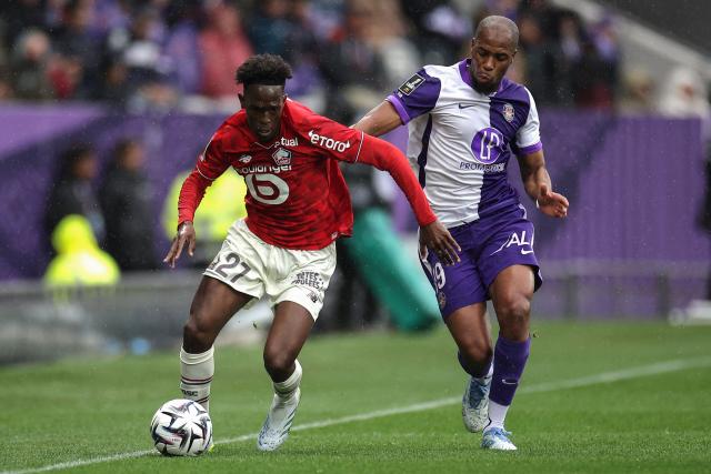 Lille's Portuguese forward #27 Felix Correia (L) fights for the ball with Toulouse's French defender #19 Djibril Sidibe (R) during the French L1 football match between Toulouse FC and Lille LOSC at the TFC Stadium in Toulouse, southwestern France, on April 12, 2026. (Photo by Valentine CHAPUIS / AFP)