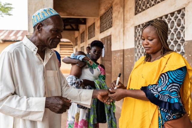A voter gets his thumb marked with indelible ink after voting at a polling station set up in a primary school in Lokossa on April 12, 2026 during Benin's presidential elections. (Photo by Yanick Folly / AFP)