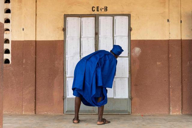 TOPSHOT - A voter looks at the voters' roll at a polling station set up in a primary school in Lokossa on April 12, 2026 during Benin's presidential elections. (Photo by Yanick Folly / AFP)