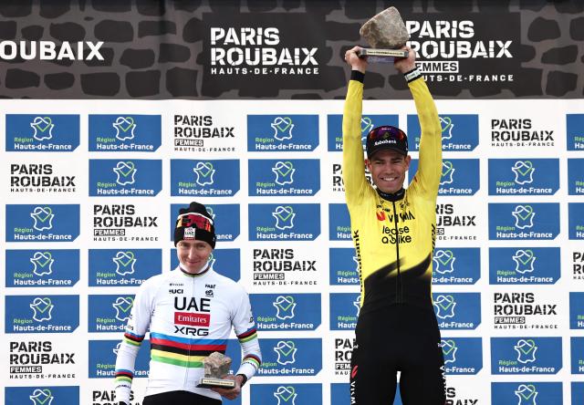 Winner Team Visma - Lease a Bike's Belgian rider Wout van Aert celebrates next to second placed UAE Team Emirates XRG's Slovenian rider Tadej Pogacar (L) on the podium of the 123rd edition of the Paris-Roubaix one-day classic cycling race, 258.3 km between Compiègne and Roubaix, at the Vélodrome André-Pétrieux in Roubaix, northern France, on April 12, 2026. (Photo by Anne-Christine POUJOULAT / AFP)