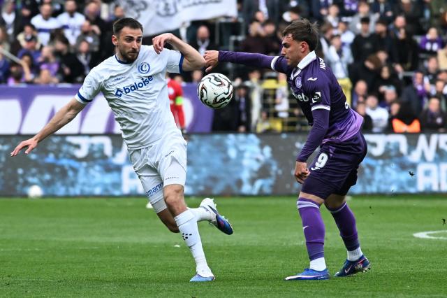Gent's Belgian defender Matties Volckaert (L) and Anderlecht's Serbian forward Mihajlo Cvetkovic (R) fight for the ball during the Belgian Pro League football match between KAA Gent and RSCA Anderlecht in Ghent on April 12, 2026. (Photo by JILL DELSAUX / Belga / AFP) / Belgium OUT