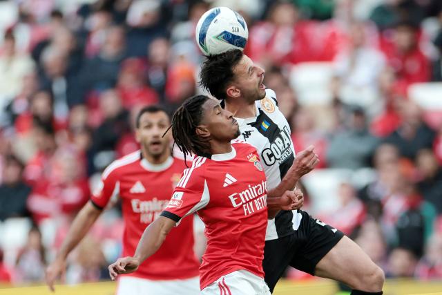 Nacional's Portuguese defender #05 Jose Gomes wins a header against SL Benfica's Luxembourgish midfielder #18 Leandro Barreiro during the Portuguese League football match between SL Benfica and CD Nacional da Madeira at Luz Stadium in Lisbon on April 12 , 2026. (Photo by PATRICIA DE MELO MOREIRA / AFP)