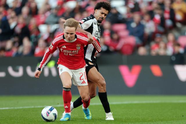 SL Benfica's Norwegian forward #21 Andreas Schjelderup and Nacional's Brazilian defender #34 Leo Santos fight for the ball during the Portuguese League football match between SL Benfica and CD Nacional da Madeira at Luz Stadium in Lisbon on April 12 , 2026. (Photo by PATRICIA DE MELO MOREIRA / AFP)