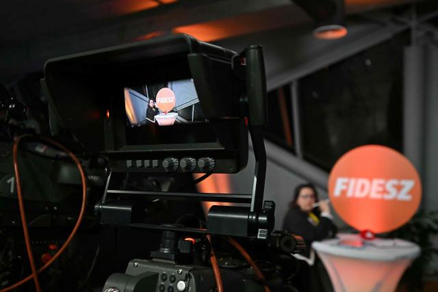 An official waits in front of a camera at the election campaign headquarters of the governing Fidesz party at the Balna centre as polls closed in Hungary's general election, in Budapest on April 12, 2026. Polls closed in Hungary's parliamentary election, with turnout reaching a record high in the crunch vote that sees nationalist Prime Minister Viktor Orban's 16-year stint in power face an unprecedented challenge from conservative political newcomer Peter Magyar. (Photo by Attila KISBENEDEK / AFP)