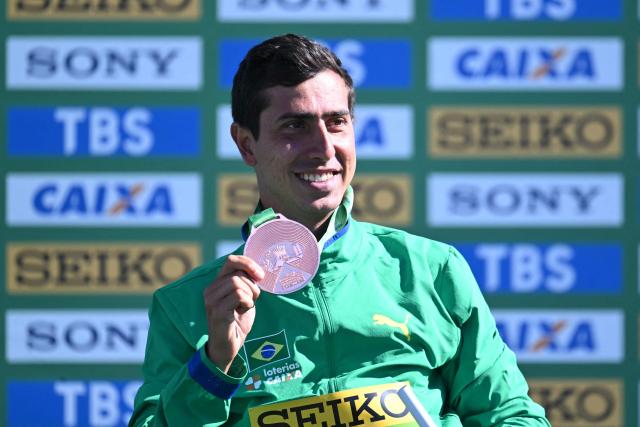Brazil's Caio Bonfim celebrates with his bronze medal during the award ceremony of the World Athletics Race Walking Team Championships men's half-marathon, in Brasilia, on April 12, 2026. (Photo by Evaristo SA / AFP)