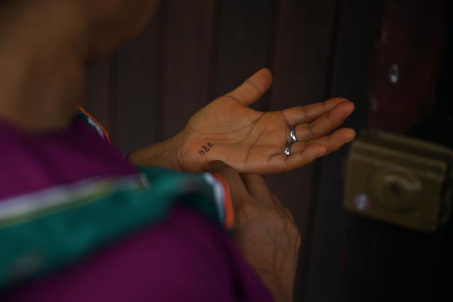 An indigenous woman looks at a number written on her hand outside a polling station in San Pablo de Tushmo, near Pucallpa, Uyacali region, Peru on April 12, 2026, during the presidential election. Peruvians will elect a new president from a record field of 35 candidates to lead a country plagued by organized crime and chronic political instability. (Photo by Hugo Alejos / AFP)
