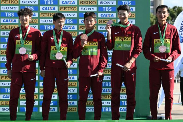 China's team members pose with their bronze medals during the award ceremony of the World Athletics Race Walking Team Championships men's team half-marathon, in Brasilia, on April 12, 2026. (Photo by Evaristo SA / AFP)