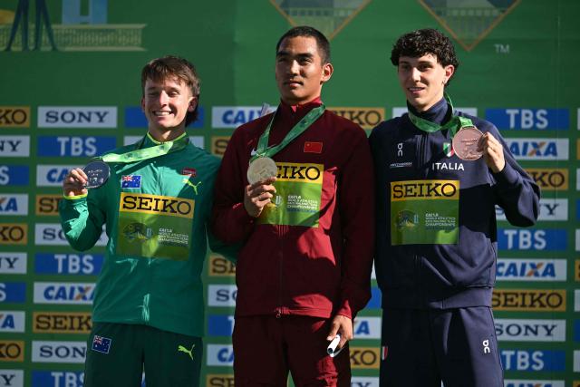 China's Pu Huajia (C) Australia's Isaac Beacroft, and Italy's Alessio Coppola celebrate their gold, silver and bronze medals respectively during the award ceremony of the World Athletics Race Walking Team Championships U20 men's 10km race, in Brasilia, on April 12, 2026. (Photo by Evaristo SA / AFP)