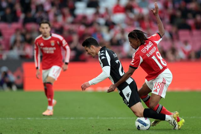 Nacional's Portuguese midfielder #22 Filipe Soares (L) and SL Benfica's Luxembourgish midfielder #18 Leandro Barreiro fight for the ball during the Portuguese League football match between SL Benfica and CD Nacional da Madeira at Luz Stadium in Lisbon on April 12 , 2026. (Photo by PATRICIA DE MELO MOREIRA / AFP)