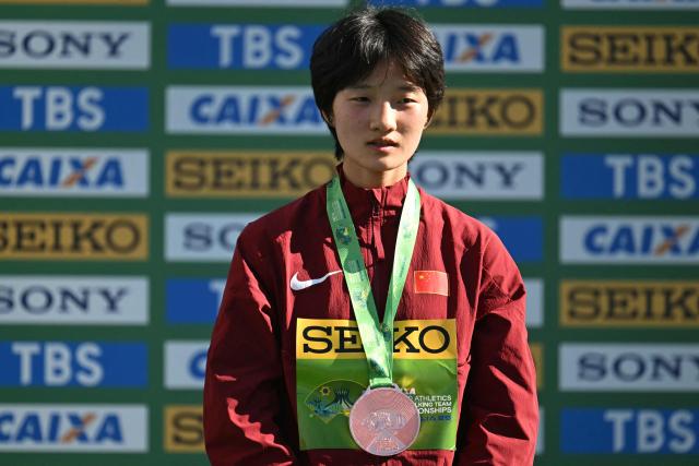 China's Ni Lihua celebrtaes her bronze medal during the award ceremony of the World Athletics Race Walking Team Championships U20 women's 10km race, in Brasilia, on April 12, 2026. (Photo by Evaristo SA / AFP)