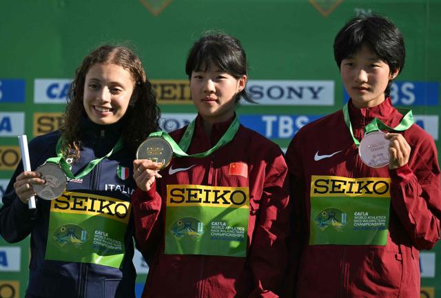 China's Yang Yutong (C), Italy's Serena Di Fabio (L), and China's Ni Lihua celebrate their gold, silver, and bronze medals during the award ceremony of the World Athletics Race Walking Team Championships U20 women's 10km race, in Brasilia, on April 12, 2026. (Photo by Evaristo SA / AFP)