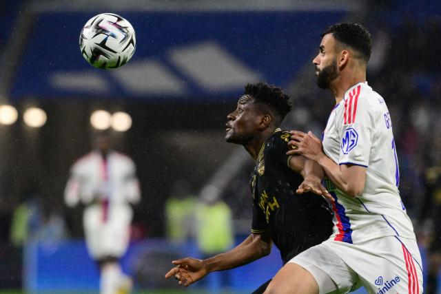 Lorient's Burkinabe defender #43 Arsene Kouassi (L) and Lyon's Algerian midfielder #18 Rachid Ghezzal (R) fight for the ball during the French L1 football match between Olympique Lyonnais (OL) and FC Lorient at the Groupama Stadium in Decines-Charpieu, central-eastern France, on April 12, 2026. (Photo by OLIVIER CHASSIGNOLE / AFP)