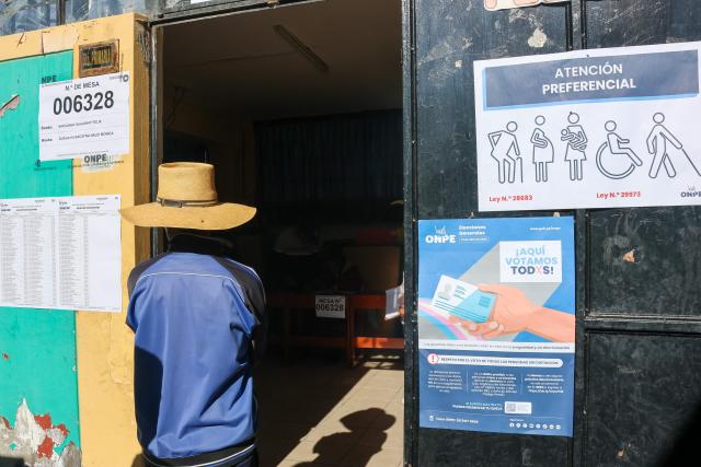 A man waits outside a polling station in the district of Chiguata, an agricultural area located some 25 kilometres from Arequipa, Peru on April 12, 2026, during general elections. Peruvians will elect a new president from a record field of 35 candidates to lead a country plagued by organized crime and chronic political instability. (Photo by Diego RAMOS / AFP)