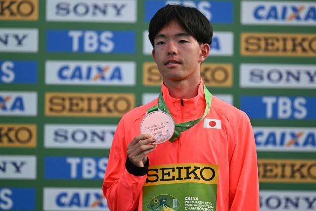 JApan's Iwai Kazuya celebrates his bronze medal during the award ceremony of the World Athletics Race Walking Team Championships men's marathon, in Brasilia, on April 12, 2026. (Photo by Evaristo SA / AFP)