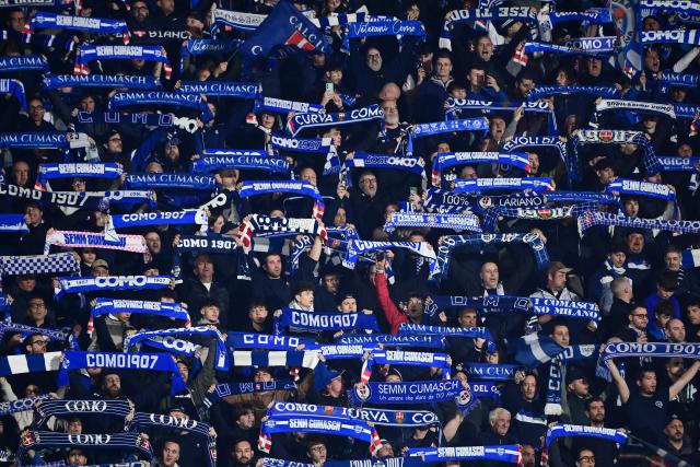 Como supporters wave scarves ahead of the Italian Serie A football match between Como and Inter Milan at the Giuseppe Sinigaglia Stadium in Como on April 12, 2026. (Photo by Piero CRUCIATTI / AFP)