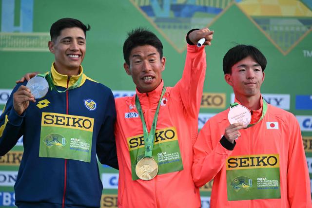 Japan's Katsuki Hayato (C), Ecuador's David Hurtado (L), and Japan's Iwai Kazuya celebrate their gold, silver and bronze medals respectively during the award ceremony of the World Athletics Race Walking Team Championships men's marathon, in Brasilia, on April 12, 2026. (Photo by Evaristo SA / AFP)