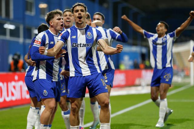FC Porto's Spanish midfielder #10 Gabriel Veiga and teammates celebrate the opening goal scored by FC Porto's Brazilian forward #11 Pepe during the Portuguese League football match between GD Estoril Praia and FC Porto at Antonio Coimbra da Mota stadium in Estoril on April 12, 2026. (Photo by FILIPE AMORIM / AFP)