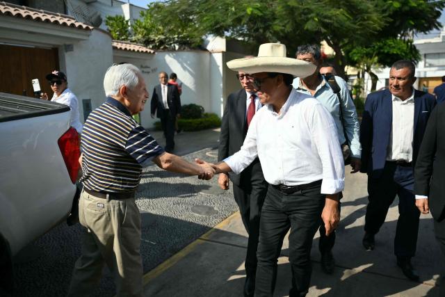 Peru's presidential candidate Roberto Sanchez (R) of the Juntos por el Peru party shakes hands with a supporter as he arrives at a polling station in Lima on April 12, 2026, during the general election. Hours-long delays marred Peru's presidential and legislative elections on Sunday, as voters sought to end political chaos that has seen a string of presidents ousted or jailed. (Photo by Luis ROBAYO / AFP)