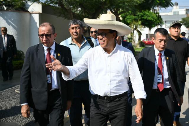 Peru's presidential candidate Roberto Sanchez (C) of the Juntos por el Peru party gestures as he arrives at a polling station in Lima on April 12, 2026, during the general election. Hours-long delays marred Peru's presidential and legislative elections on Sunday, as voters sought to end political chaos that has seen a string of presidents ousted or jailed. (Photo by Luis ROBAYO / AFP)