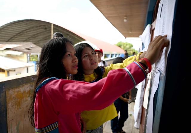 Women check for their polling station during the general election in San Pablo de Tushmo, near Pucallpa, Uyacali region, Peru on April 12, 2026. Peruvians head to the polls to elect its ninth president in a decade, from a record field of 35 candidates, with crime-weary voters seemingly poised to extend the tide of conservative governments sweeping Latin America. (Photo by Hugo Alejos / AFP)