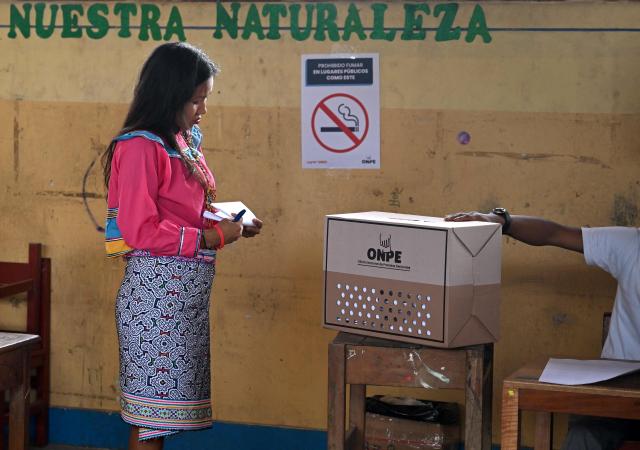 A woman prepares to vote at a polling station during the general election in San Pablo de Tushmo, near Pucallpa, Uyacali region, Peru on April 12, 2026. Peruvians head to the polls to elect its ninth president in a decade, from a record field of 35 candidates, with crime-weary voters seemingly poised to extend the tide of conservative governments sweeping Latin America. (Photo by Hugo Alejos / AFP)
