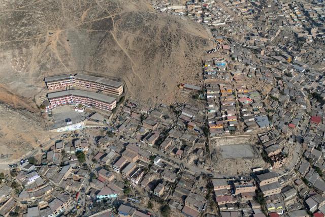 Aerial view of Fe y Alegria 65 school polling station in Pamplona Alta, San Juan de Miraflores district on the outskirts of Lima on April 12, 2026. Peruvians head to the polls to elect its ninth president in a decade, from a record field of 35 candidates, with crime-weary voters seemingly poised to extend the tide of conservative governments sweeping Latin America. (Photo by Ernesto BENAVIDES / AFP)