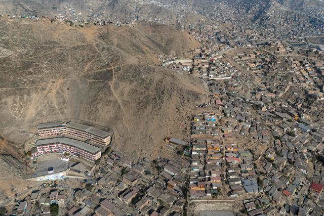Aerial view of Fe y Alegria 65 school polling station in Pamplona Alta, San Juan de Miraflores district on the outskirts of Lima on April 12, 2026. Peruvians head to the polls to elect its ninth president in a decade, from a record field of 35 candidates, with crime-weary voters seemingly poised to extend the tide of conservative governments sweeping Latin America. (Photo by Ernesto BENAVIDES / AFP)