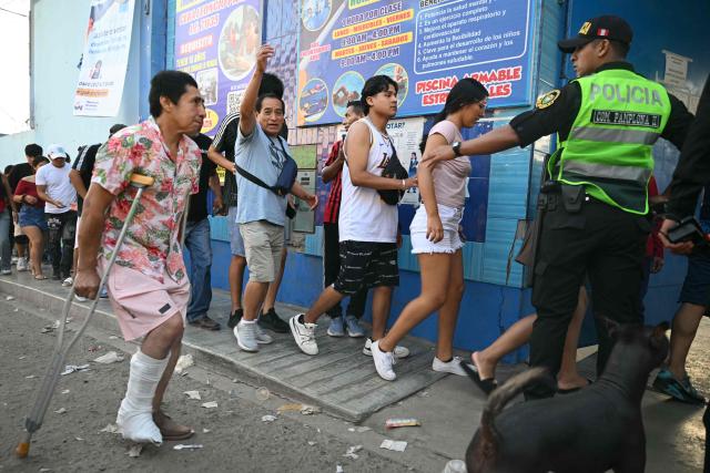 People line up to cast their votes at a school polling station in Pamplona Alta, in the San Juan de Miraflores district on the outskirts of Lima, on April 12, 2026. Hours-long delays marred Peru's presidential and legislative elections on April 12, as voters sought to end political chaos that has seen a string of presidents ousted or jailed. (Photo by Ernesto BENAVIDES / AFP)