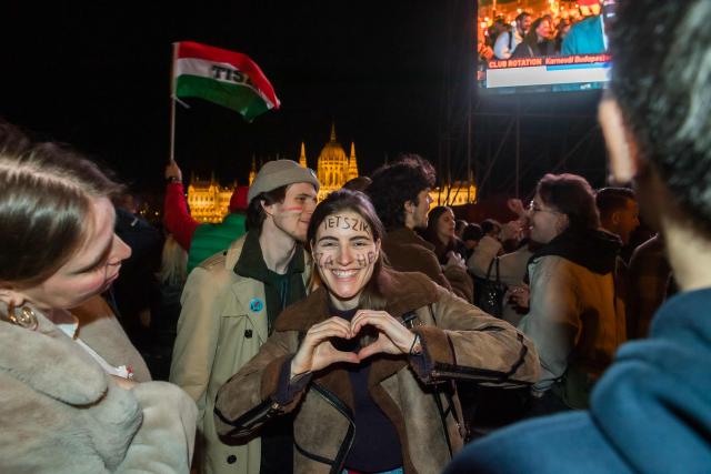 People celebrate in the streets after Peter Magyar, leader of the pro-European conservative TISZA party, addressed supporters at their election night party in Budapest during the general election in Hungary, on April 12, 2026. Polls closed in Hungary's parliamentary election, with turnout reaching a record high in the crunch vote that sees nationalist Prime Minister Viktor Orban's 16-year stint in power face an unprecedented challenge from conservative political newcomer Peter Magyar. (Photo by Ferenc ISZA / AFP)