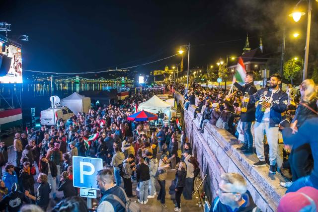 People celebrate in the streets after Peter Magyar, leader of the pro-European conservative TISZA party, addressed supporters at their election night party in Budapest during the general election in Hungary, on April 12, 2026. Polls closed in Hungary's parliamentary election, with turnout reaching a record high in the crunch vote that sees nationalist Prime Minister Viktor Orban's 16-year stint in power face an unprecedented challenge from conservative political newcomer Peter Magyar. (Photo by Ferenc ISZA / AFP)