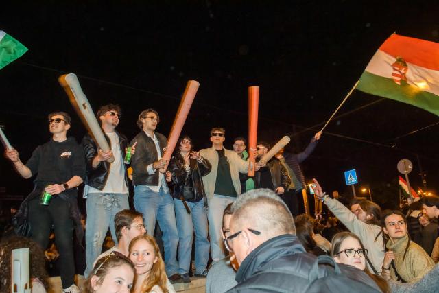People celebrate in the streets after Hungarian Prime Minister Viktor Orban conceded defeat to Peter Magyar, leader of the pro-European conservative TISZA party, in Budapest, on April 12, 2026. Polls closed in Hungary's parliamentary election, with turnout reaching a record high in the crunch vote that sees nationalist Prime Minister Viktor Orban's 16-year stint in power face an unprecedented challenge from conservative political newcomer Peter Magyar. (Photo by Ferenc ISZA / AFP)